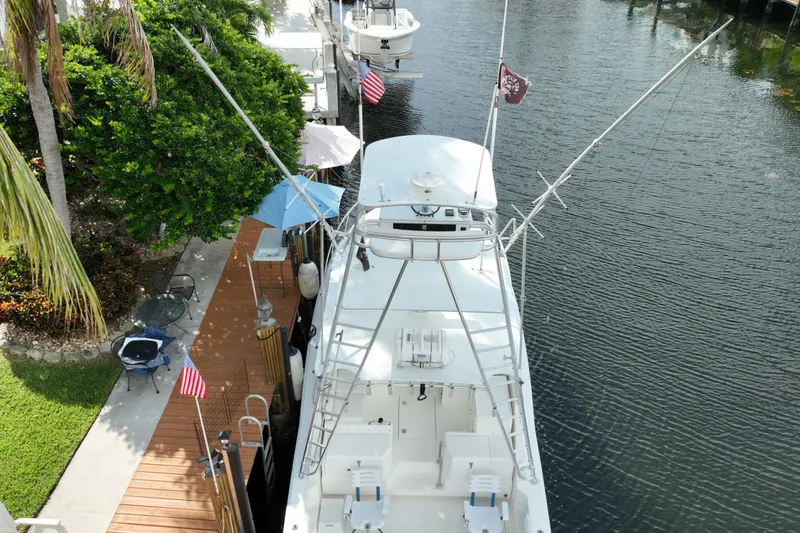 Slide: The Image of Aerial view of a 2002 Cabo 35 Express boat docked by a lush, green shoreline. - 7