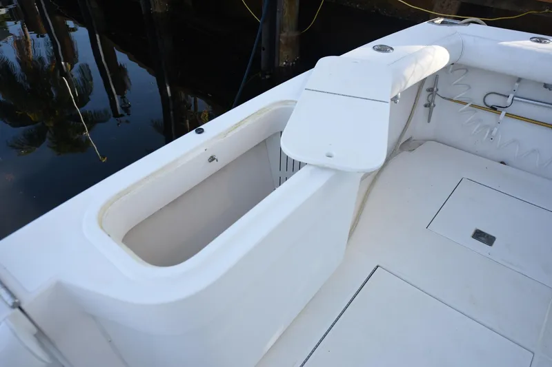 Slide: The Image of 2002 Cabo 35 Express boat deck with storage compartment and seating area. - 18