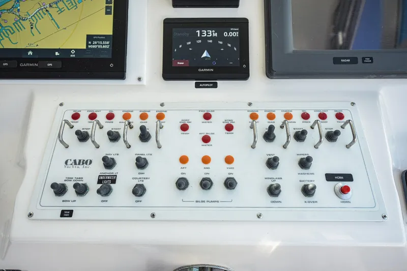 Slide: The Image of Control panel of a 2002 Cabo 35 Express yacht with navigation and system switches. - 57