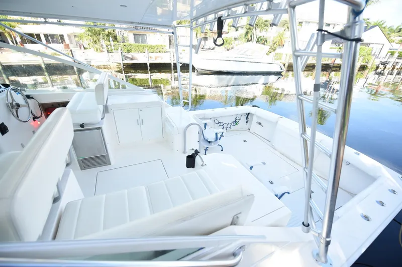 Slide: The Image of 2002 Cabo 35 Express boat interior with white seating and fishing equipment. - 44