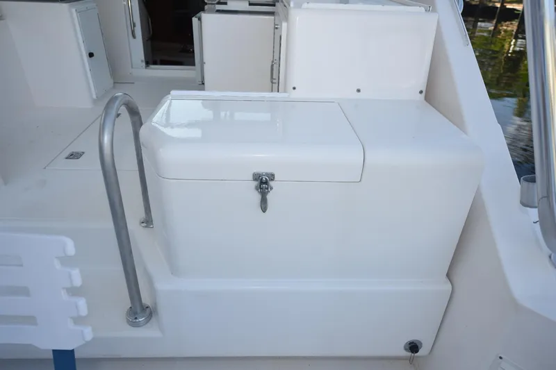 Slide: The Image of 2002 Cabo 35 Express boat deck with storage compartment and railing. - 26