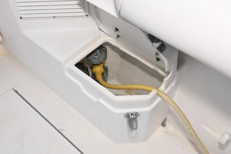 Slide: The Image of 2002 Cabo 35 Express boat compartment with yellow hose and metal fittings. - 24