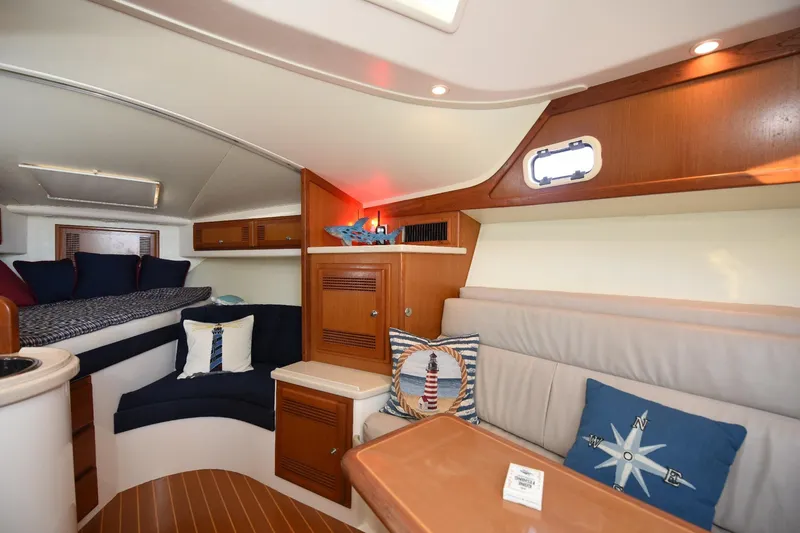 Slide: The Image of Interior of 2002 Cabo 35 Express boat with cozy seating and nautical decor. - 70