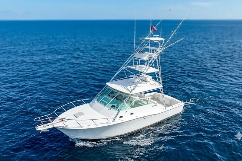 The Image of 2002 Cabo 35 Express yacht cruising on open blue ocean waters. - 0