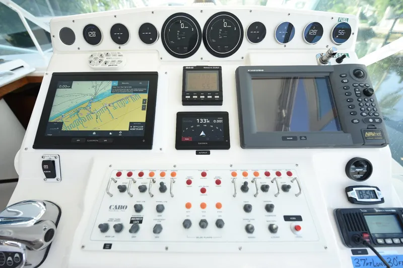 Slide: The Image of Control panel of a 2002 Cabo 35 Express boat with navigation and communication equipment. - 58