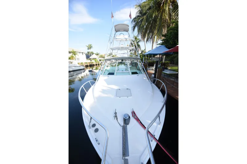 Slide: The Image of 2002 Cabo 35 Express boat docked near palm trees and waterfront homes. - 37