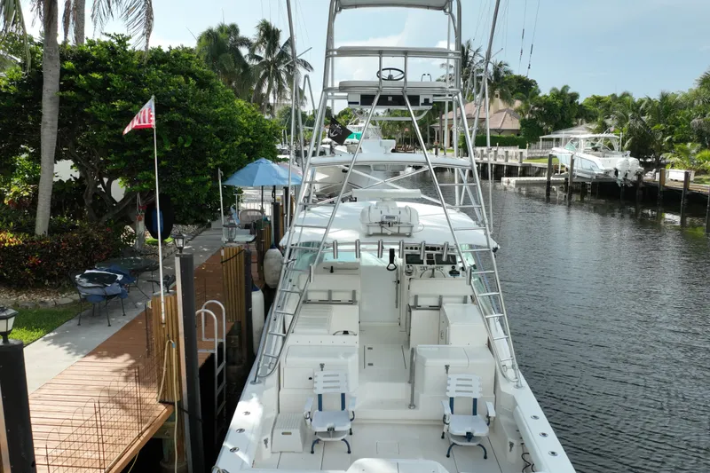 Slide: The Image of 2002 Cabo 35 Express boat docked by a lush, tropical canal setting. - 6