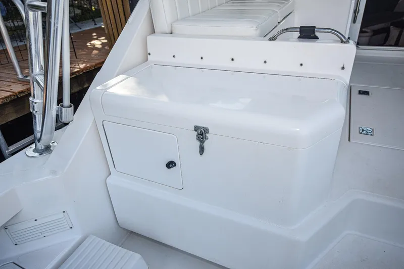 Slide: The Image of 2002 Cabo 35 Express boat interior with white seating and storage compartment. - 29