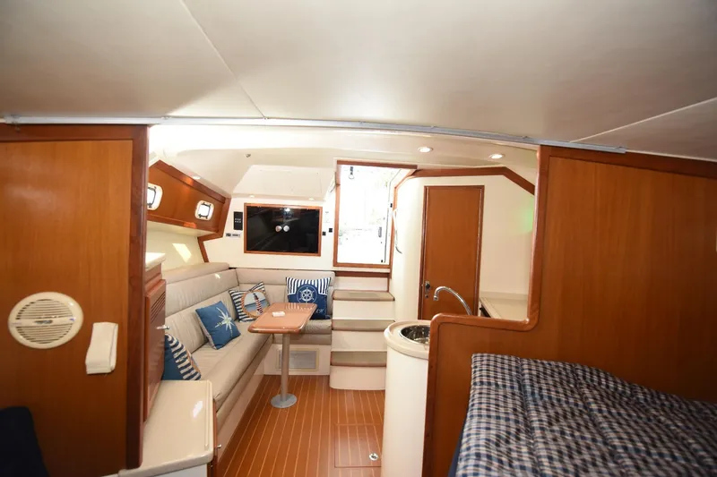 Slide: The Image of Interior of 2002 Cabo 35 Express yacht with cozy seating and wooden finishes. - 80