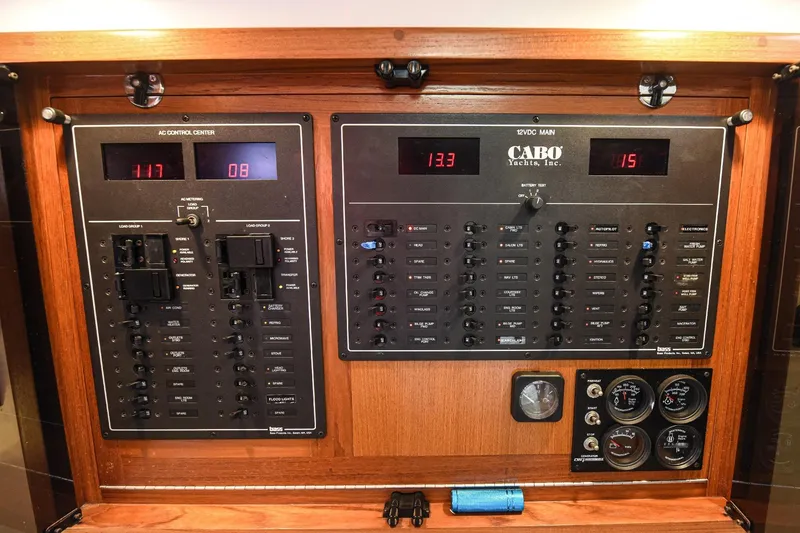 Slide: The Image of Electrical control panel of a 2002 Cabo 35 Express yacht, featuring various switches and gauges. - 97