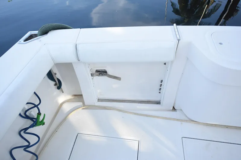Slide: The Image of 2002 Cabo 35 Express boat deck with storage compartment and coiled hose. - 19
