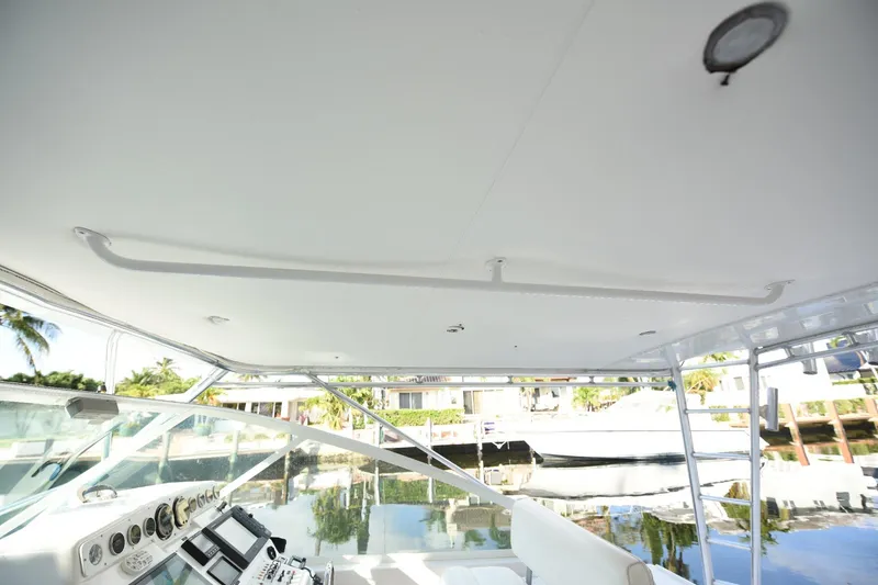 Slide: The Image of 2002 Cabo 35 Express boat interior with helm, controls, and waterfront view. - 64