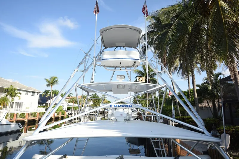 Slide: The Image of 2002 Cabo 35 Express boat docked, surrounded by palm trees and clear blue sky. - 40