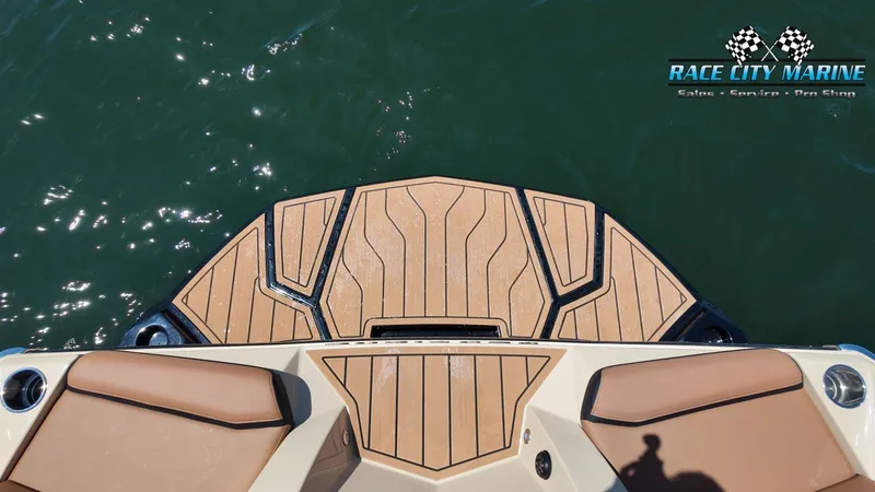 Slide: The Image of The image shows the stern of a 2027 Nautique G23 boat with a sleek teak deck. - 28