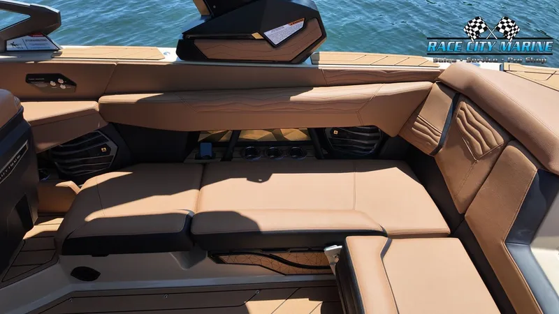 Slide: The Image of The image shows the interior of a 2027 Nautique G23 boat with brown leather seating. - 21