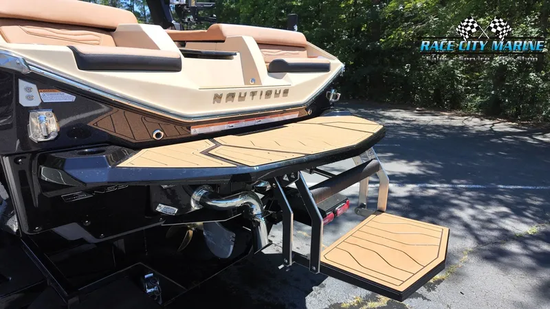 Slide: The Image of The image shows the rear of a 2027 Nautique G23 boat with a swim platform and ladder. - 14