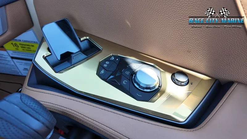 Slide: The Image of Close-up of a control panel in a 2027 Nautique G23 boat with gold accents. - 27
