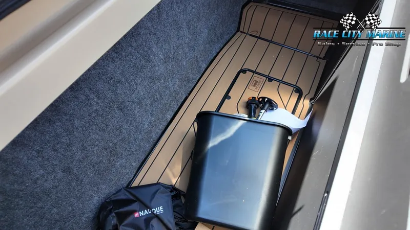 Slide: The Image of A storage compartment in the boat with a black container and a Nautique bag. - 19