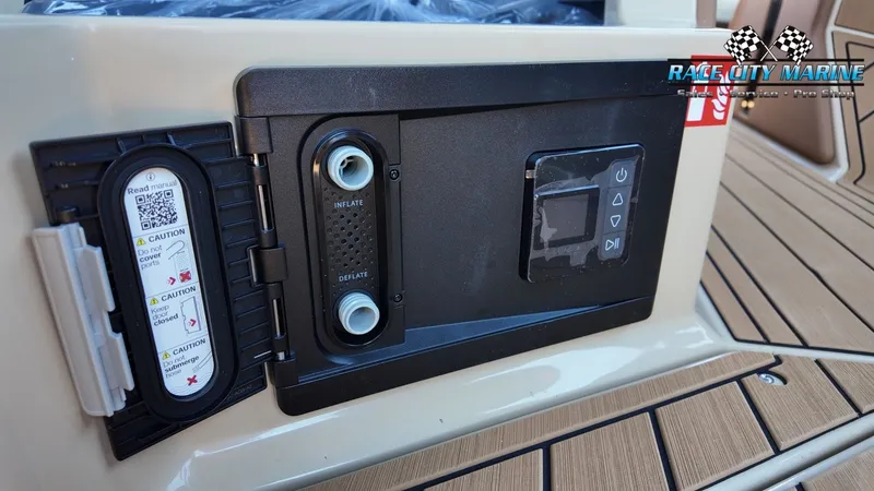 Slide: The Image of Close-up of a control panel on a 2027 Nautique G23 boat with controls and warning labels. - 45