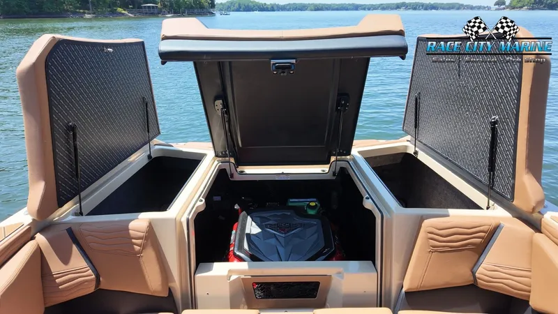 Slide: The Image of The image shows the engine compartment of a 2027 Nautique G23 boat, situated on a lake. - 17
