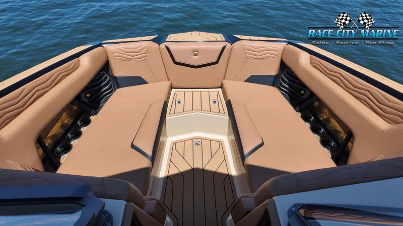 Slide: The Image of The image shows the bow of a Nautique G23 boat with luxurious brown upholstery and cup holders. - 26