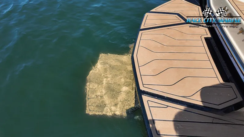 Slide: The Image of The image shows the stern of a 2027 Nautique G23 boat in the water. - 15