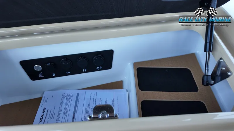 Slide: The Image of A boat storage compartment with switches and documents. A hydraulic arm holds the lid open. - 25