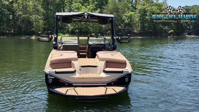 Slide: The Image of A modern Nautique G23 boat from 2027 floats on a calm lake, surrounded by trees. - 4