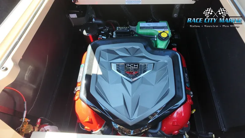 Slide: The Image of The engine compartment of a 2027 Nautique G23 with a PCM engine, surrounded by red casing. - 18
