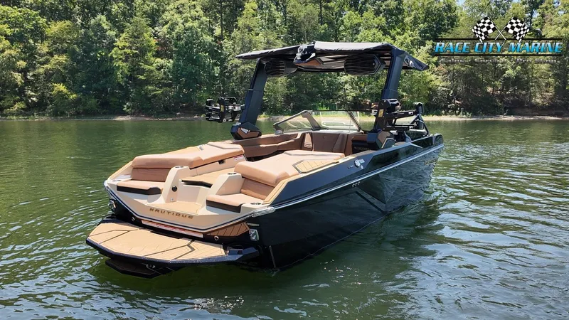 Slide: The Image of A sleek, modern boat with brown seating and a black hull floats on a calm lake. - 8