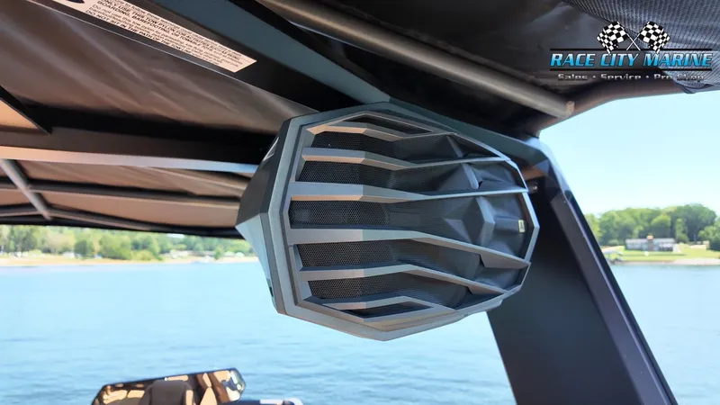 Slide: The Image of A speaker is mounted on a boat, overlooking a calm lake and wooded shores. - 38