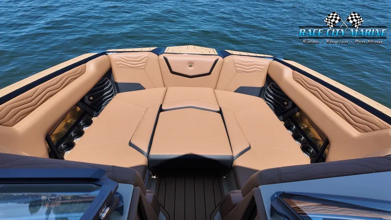 Slide: The Image of The image shows the bow of a Nautique G23 boat with luxurious beige upholstery and cup holders. - 39