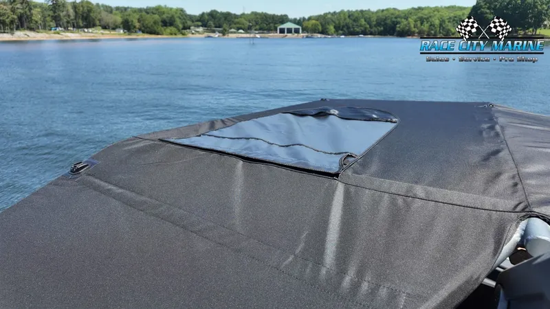 Slide: The Image of The image shows the cover of a Nautique G23 boat on a calm lake. - 32
