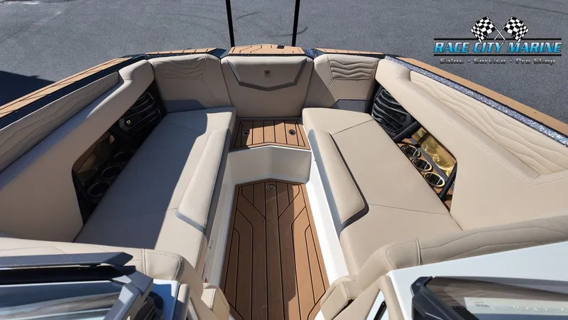 Slide: The Image of The image shows the luxurious cockpit of a 2027 Nautique G25 with beige upholstery and wood flooring. - 35