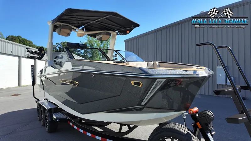 Slide: The Image of The image shows a modern 2027 Nautique G25 boat on a trailer, ready for use. - 5