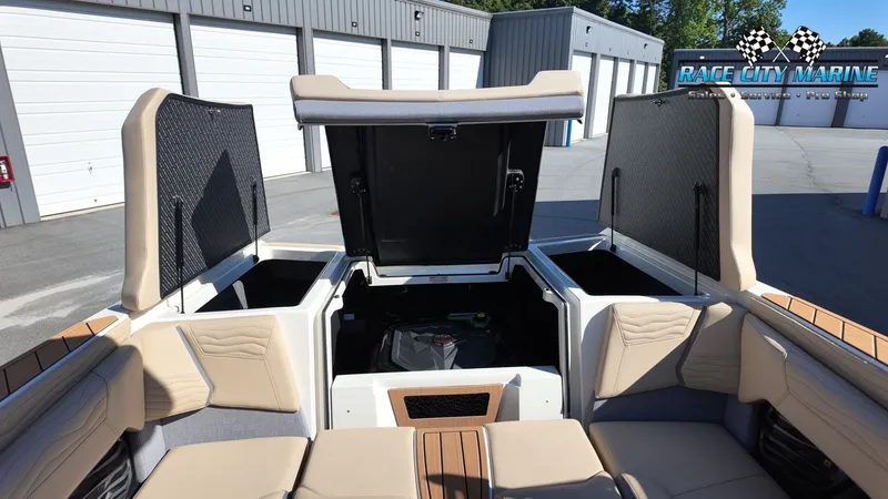 Slide: The Image of The image shows the open rear of a Nautique G25 boat with storage compartments and cushioned seats. - 38