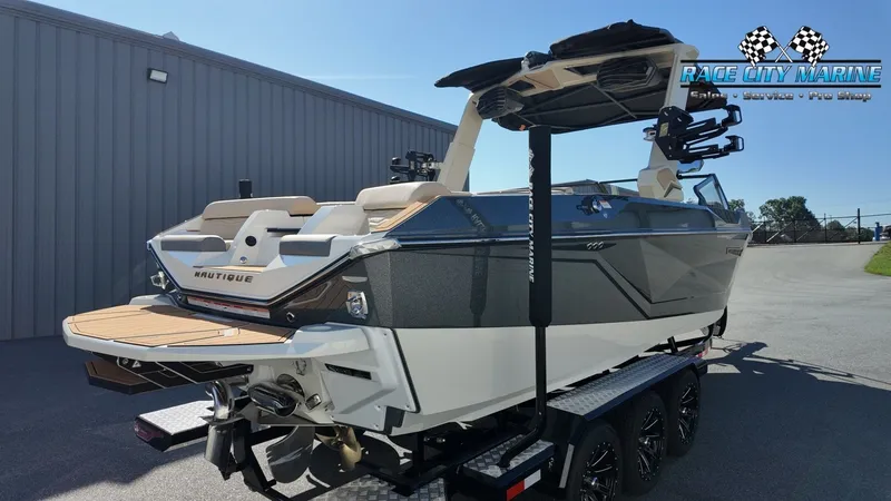 Slide: The Image of A modern Nautique G25 boat from 2027 sits on a trailer outside a building. - 8