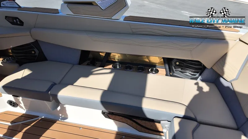 Slide: The Image of Interior view of a 2027 Nautique G25 with beige upholstery and cup holders. - 44