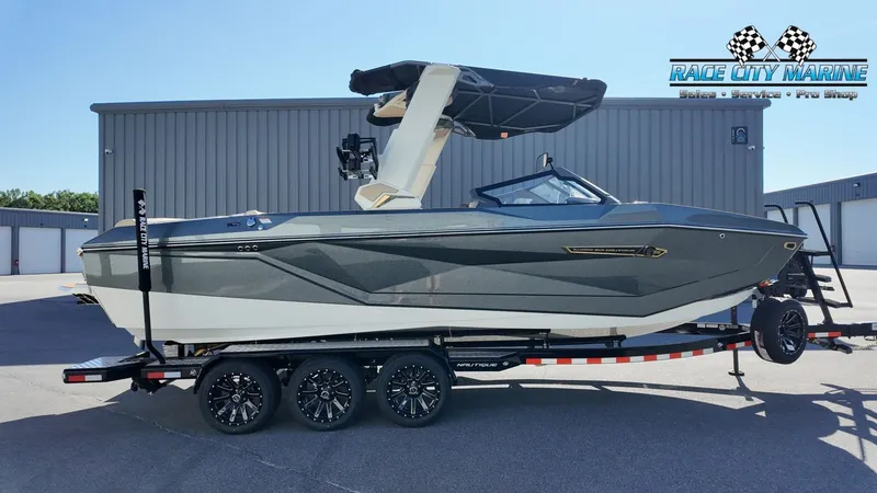 The Image of A modern 2027 Nautique G25 boat on a trailer, featuring a black sunshade. - 1