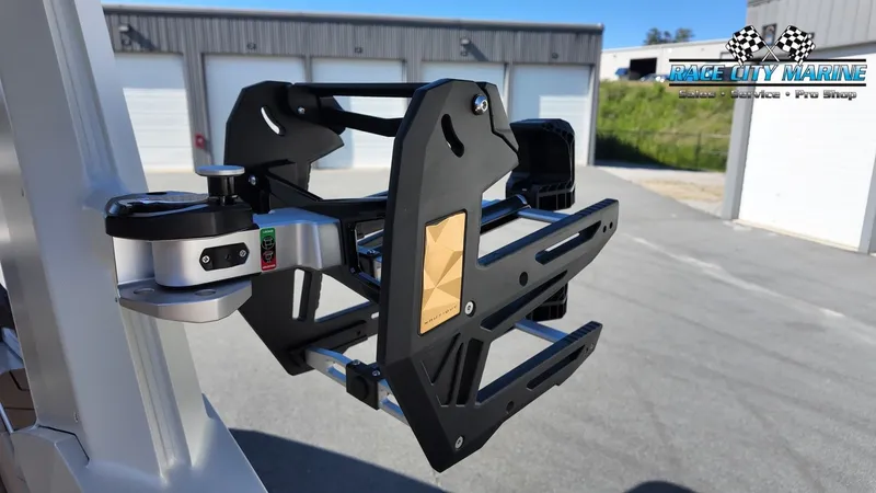 Slide: The Image of A modern wakeboard rack on a Nautique G25 boat, in front of a building with garages. - 26