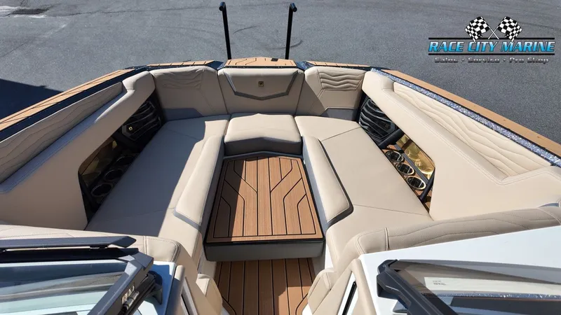 Slide: The Image of The image shows the bow area of a Nautique G25 boat with beige upholstery and wood flooring. - 27