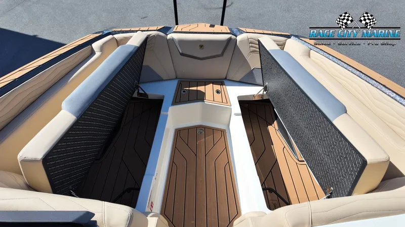 Slide: The Image of The image shows the interior of a Nautique G25 boat with cushioned seats and wooden flooring. - 47