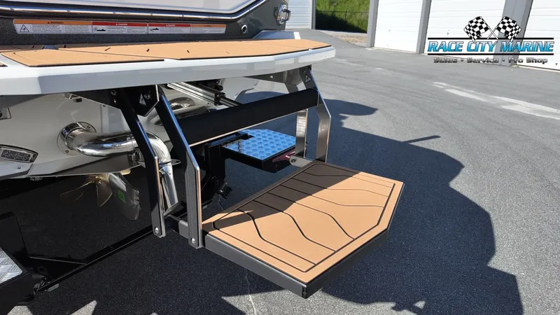 Slide: The Image of The 2027 Nautique G25 features a sleek swim platform with non-slip decking and a retractable ladder. - 9
