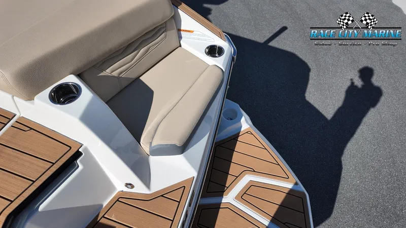 Slide: The Image of The image shows the stern of a 2027 Nautique G25 with sleek upholstery and teak detailing. - 50