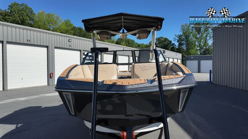 Slide: The Image of A modern Nautique G25 boat is parked in front of garages. It features a sleek design. - 3
