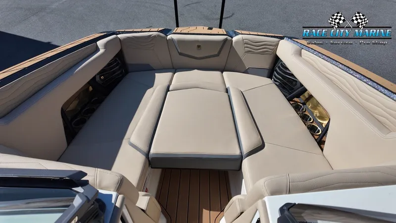 Slide: The Image of The image shows the bow area of a Nautique G25 boat with beige upholstery and cup holders. - 18