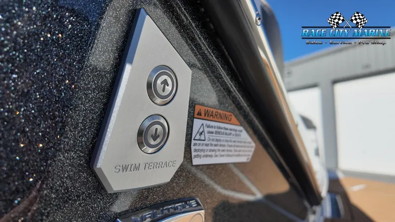 Slide: The Image of Close-up of the swim terrace control buttons on a Nautique G25 boat. - 37