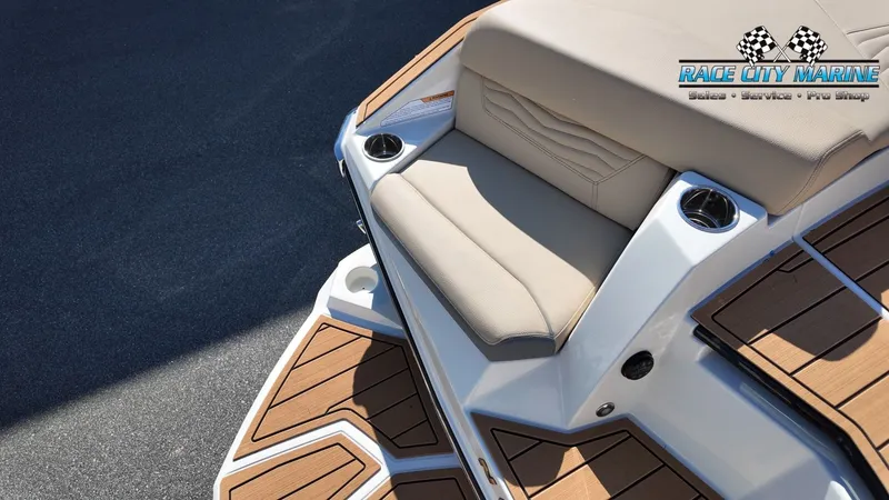 Slide: The Image of The image shows the stern of a Nautique G25 boat with a beige seat and teak-style flooring. - 17