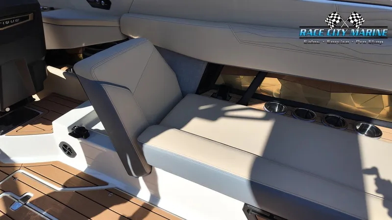 Slide: The Image of The image shows the interior of a 2027 Nautique G25 with beige seating and cup holders. - 41