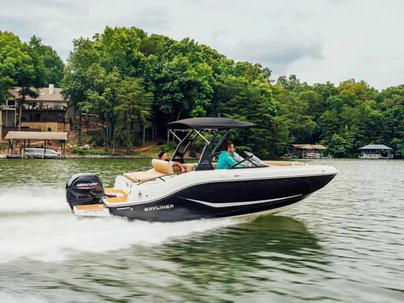 The Image of A 2027 Bayliner D20 speeds across a calm lake, surrounded by trees. - 1